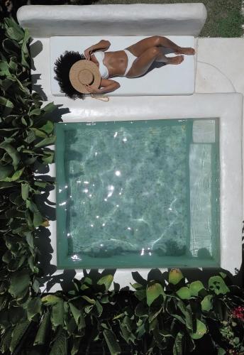 a man in a hat next to a swimming pool at Vila Oyá - Praia de Algodões in Marau