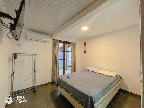 a bedroom with a bed in a room with a window at Linda suíte à 300m da Praia do Pequeá no Saco da Capela in Ilhabela