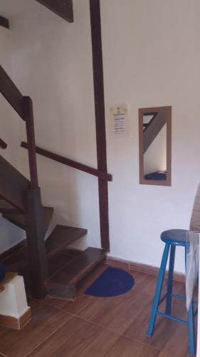 a staircase in a room with a table and a stool at SUITES E CHALES PRIVADOS Rock's&Rose's home in Camburi