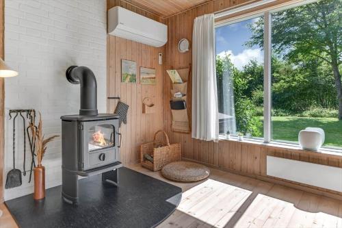 a wood stove in a room with a window at BV310-Blavand-Gronnevej-16 in Blåvand