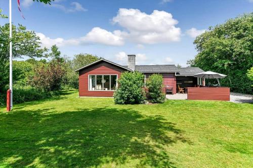 a red house with a large yard at BV310-Blavand-Gronnevej-16 in Blåvand