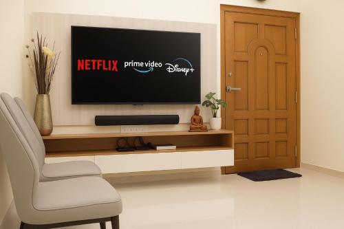 a living room with a tv and a chair and a door at Brand New 3BR Condo 5 Min Walk to T Nagar Shopping in Chennai