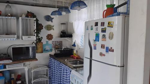 a kitchen with a refrigerator and a sink at Casa beiramar, vista mar e pinheiros, pé na areia in Xangri-lá