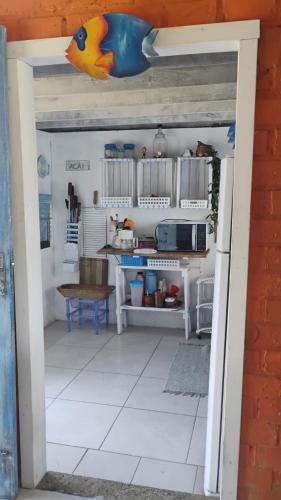 an open door into a kitchen with a table at Casa beiramar, vista mar e pinheiros, pé na areia in Xangri-lá