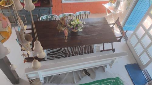 an overhead view of a wooden bench with flowers on it at Casa beiramar, vista mar e pinheiros, pé na areia in Xangri-lá