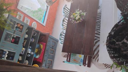 a room with a wall with a cabinet and a vase of flowers at Casa beiramar, vista mar e pinheiros, pé na areia in Xangri-lá