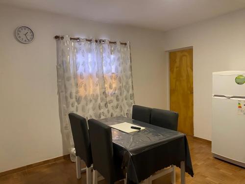 a dining room with a table and chairs and a refrigerator at Departamento turístico Cloe 2 in Fiambala