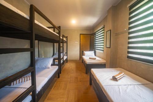a room with three bunk beds in a dorm at FOREVER SIARGAO in General Luna