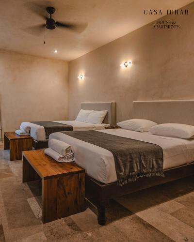 a hotel room with two beds and two tables at Casa Junab - Casa-House in El Cuyo
