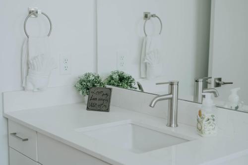 a white bathroom with a sink and a mirror at Beehive Haven in Salt Lake City
