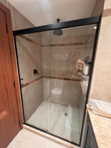 a glass shower with a person sitting at a table at Buona Vitta Gramado in Gramado