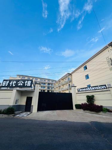 aartment building with a building with a sign on it at Times Mansion king size standard room in Freetown