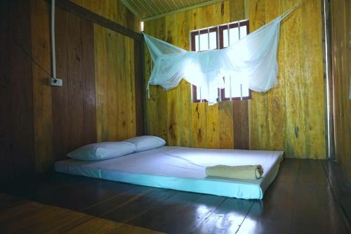a bed in a wooden room with a window at Nhà nghỉ Quang Hưng in Ba Be