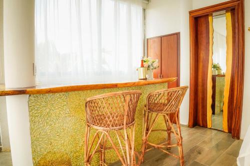 two chairs sitting at a bar in a room at Muúnek Hotel Boutique Art & Spa, adults only in Barra Vieja