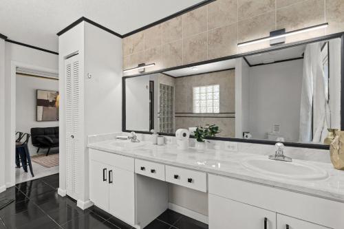a white bathroom with a sink and a mirror at Doral Beach in Tampa