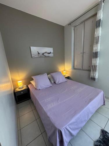 a bedroom with a large bed with two lamps at La Parenthèse Enchantée Avignon in Avignon