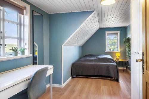 a bedroom with a bed and a blue wall at 266-Harboore-Strandvejen-177-A in Harboør