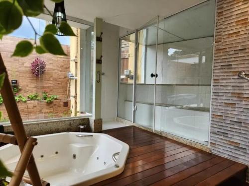 a bathroom with a tub and a glass shower at Casa das Hortênsias in Teresópolis