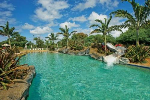 a water slide in a pool at a resort at Poipu Beach Bungalow in Koloa