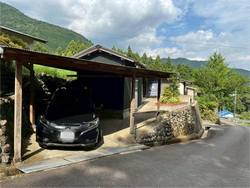 a car parked in a garage next to a house at Cottage Kirihata in Tanabe