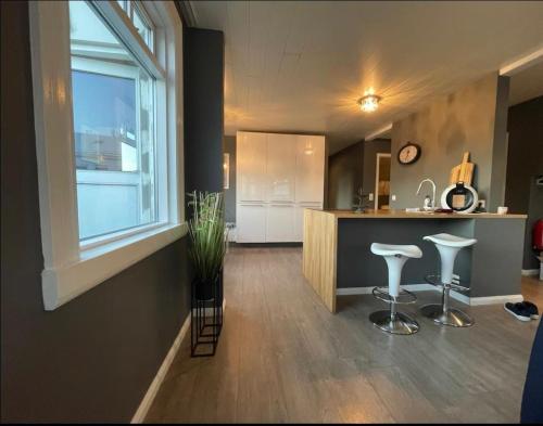 a kitchen with a counter and stools in a room at LUXURIOUS COMFORTABLE Family Villaes in Akureyri
