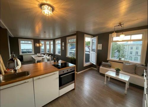 a kitchen with white cabinets and a living room at LUXURIOUS COMFORTABLE Family Villaes in Akureyri