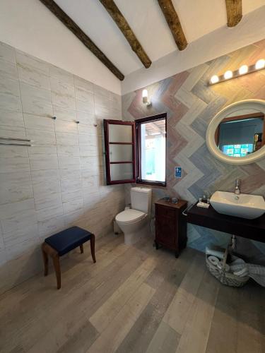 a bathroom with a toilet and a sink and a mirror at Monte da Freira in Bencatel