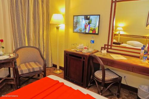 a hotel room with a desk and a mirror at Resta Port Said Hotel in Port Said