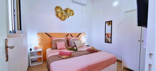 a bedroom with two beds with pink sheets at Bungalow Pink Lemon & SPA in Anse-Bertrand