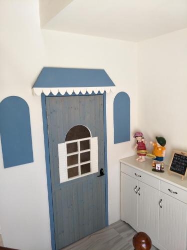 a kitchen with a blue door with a window at Misto B&B in Taitung City