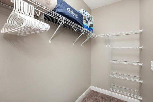 a walk in closet with white walls and white shelves at Exclusive, Pool, Massage Chair, Jordan Creek in West Des Moines