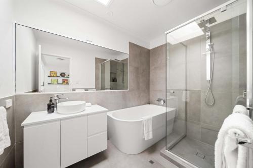 a white bathroom with a sink and a shower at Hidden Gem 200m to Mooloolaba Beach in Mooloolaba
