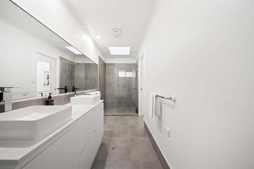 a white bathroom with two sinks and a shower at Hidden Gem 200m to Mooloolaba Beach in Mooloolaba