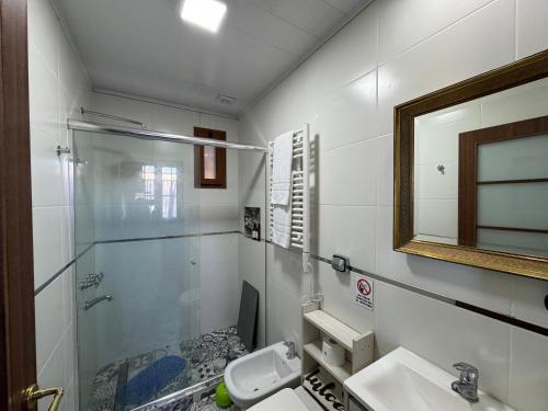 Un baño con ducha, lavabo y espejo. en Como Entonces Casa, en Uribelarrea