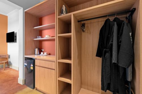 a walk in closet with wooden walls and shelves at Royal Mail Hotel in Tewantin