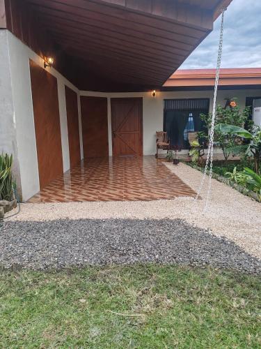 a porch of a house with a swing at Lodge Lake Arenal in Tilarán