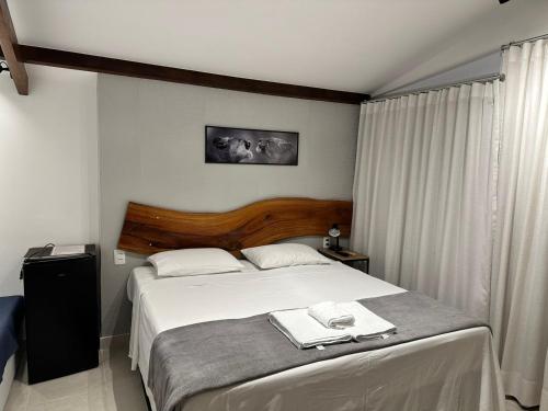 a bedroom with a bed with two towels on it at Kim Casa BH in Belo Horizonte