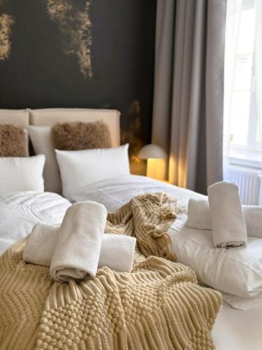 a bed with white blankets and pillows on it at TINTURA by BAST - Wanna, Antresola, OFF Piotrkowska, EC1 ,Stajnia Jednorożca, Winda, Parking na Terenie, Orientarium, Hopa Lupa, ATLAS ARENA in Łódź