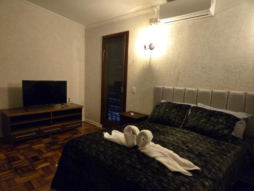 a hotel room with a bed with towels on it at Elegant House with Party Room in Santana do Livramento