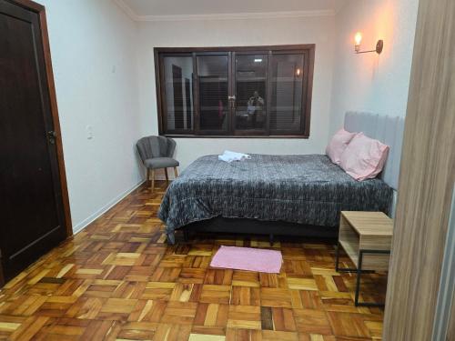 a bedroom with a bed and a wooden floor at Elegant House with Party Room in Santana do Livramento
