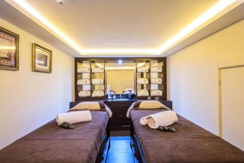two beds in a room with a vanity and shelves at Vila Galé Estoril in Estoril