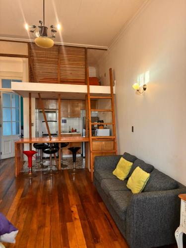 un soggiorno con un divano e un letto a soppalco di Loft Waddington a Valparaíso