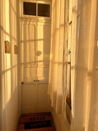 una porta bianca con tende in una stanza di Loft Waddington a Valparaíso