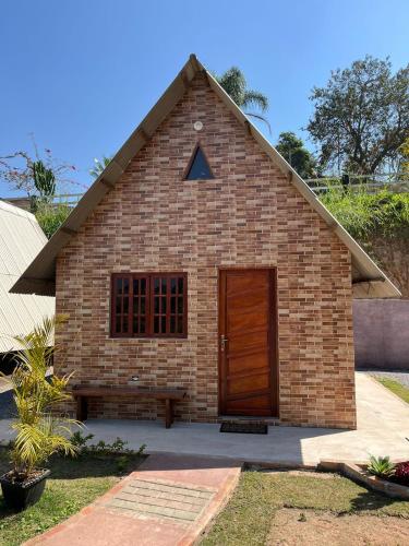 a small brick building with a wooden door at Chalé Paraíso Guararema 1 in Guararema