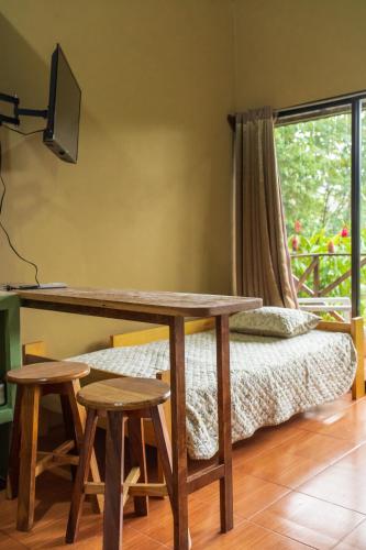 a room with a desk and a bed with a window at Rio Celeste Dreams in Bijagua