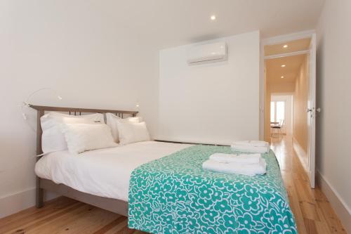 リスボンにあるFLH Alfama Bright Apartmentのベッドルーム1室(ベッド1台、テーブル、タオル付)