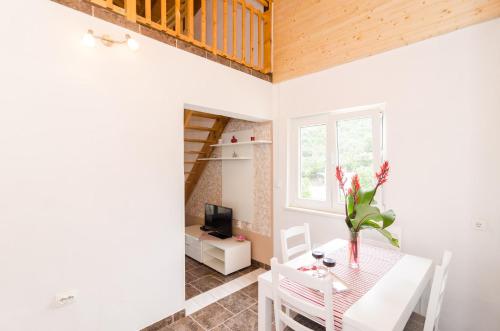 a dining room with a table with a vase of flowers at Apartments LeviAna in Saplunara