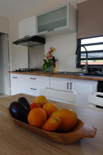 a bowl of fruit on a table in a kitchen at Aumihi Bungalow in HUH