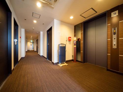 an empty hallway of an office building with a hallway at Super Hotel Towada in Towada
