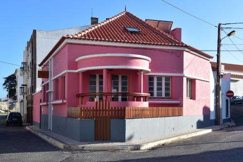 a pink house on the side of a street at Mercearia D'Alegria Boutique B&B in Peniche